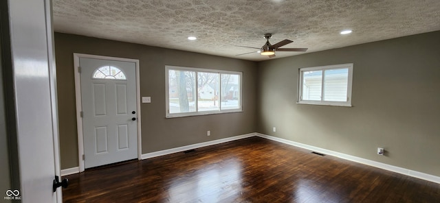 entryway with ceiling fan, dark hardwood / wood-style floors, and a textured ceiling