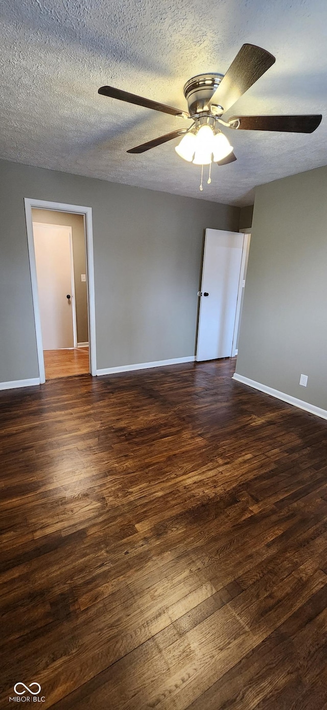 spare room with ceiling fan, dark hardwood / wood-style floors, and a textured ceiling