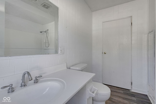 bathroom with hardwood / wood-style floors, sink, tile walls, backsplash, and toilet