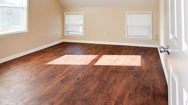 unfurnished room with vaulted ceiling and dark hardwood / wood-style floors