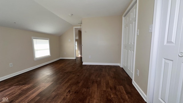 interior space featuring lofted ceiling, dark hardwood / wood-style floors, and a closet