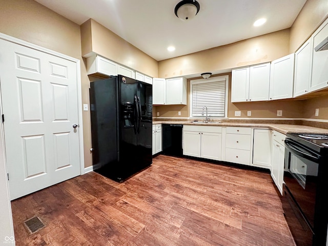 kitchen featuring white cabinetry, sink, light wood-type flooring, and black appliances