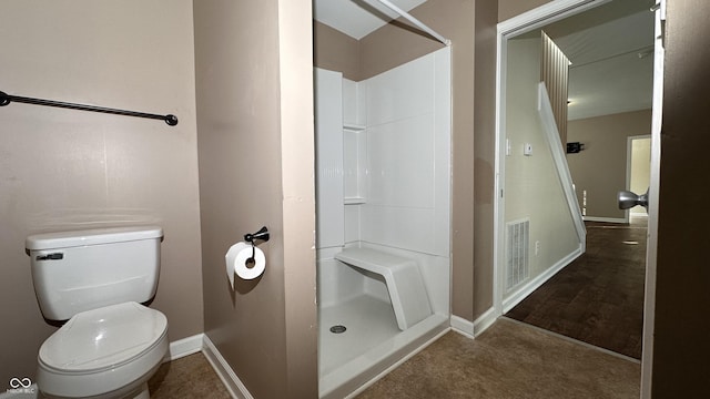 bathroom with toilet and a shower