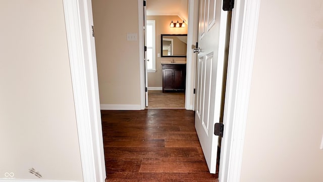 hallway featuring dark wood-type flooring and sink