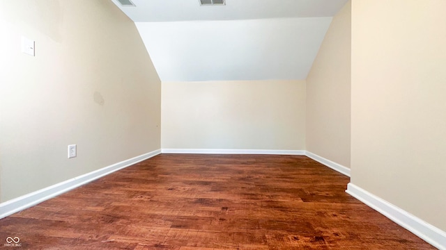 additional living space with dark hardwood / wood-style floors and vaulted ceiling