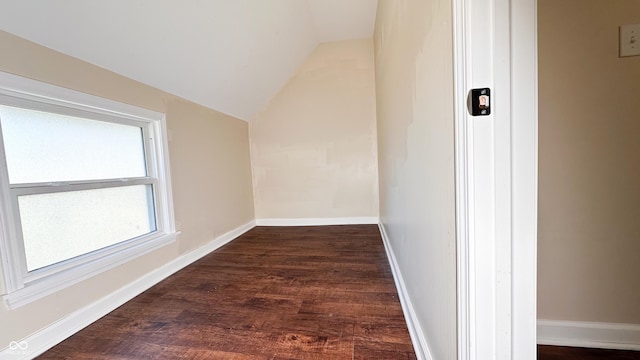 additional living space with dark wood-type flooring and vaulted ceiling