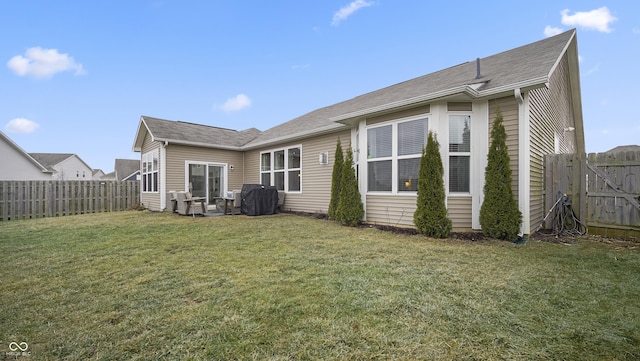 rear view of house featuring a yard