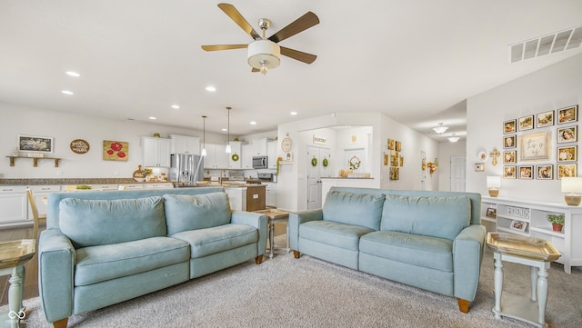 carpeted living room with ceiling fan