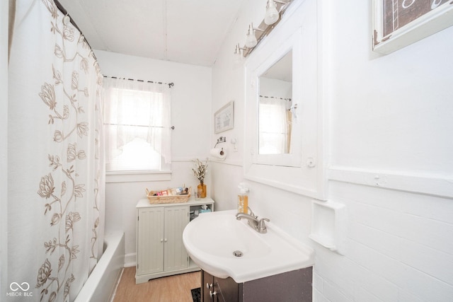 bathroom featuring vanity, hardwood / wood-style floors, and shower / bath combo with shower curtain