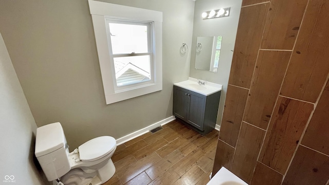 bathroom featuring wood-type flooring, vanity, and toilet