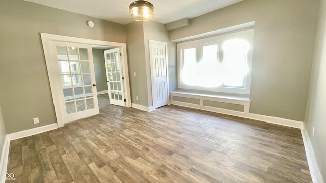 unfurnished room featuring french doors and hardwood / wood-style floors