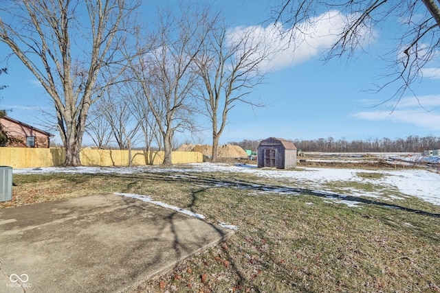 yard covered in snow with a patio area, a shed, and central air condition unit