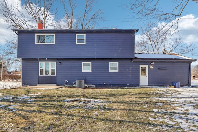 back of house with central AC and a lawn