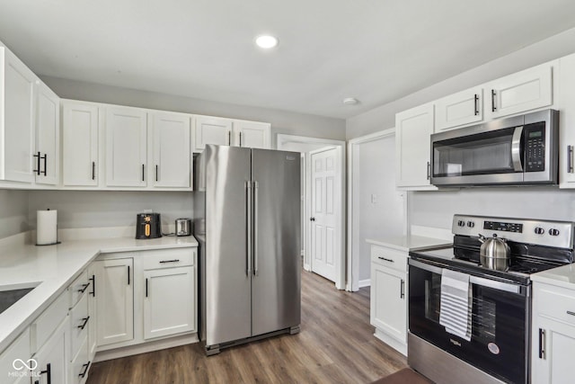 kitchen featuring white cabinetry, appliances with stainless steel finishes, and dark hardwood / wood-style floors