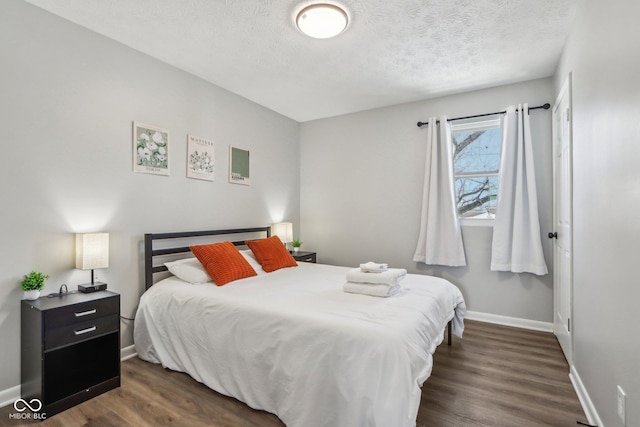 bedroom featuring dark hardwood / wood-style floors and a textured ceiling