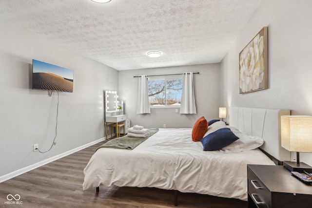 bedroom with dark wood-type flooring and a textured ceiling