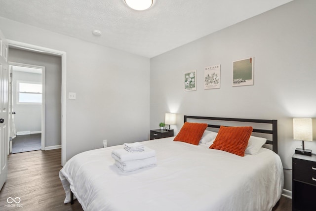 bedroom featuring dark wood-type flooring and a textured ceiling