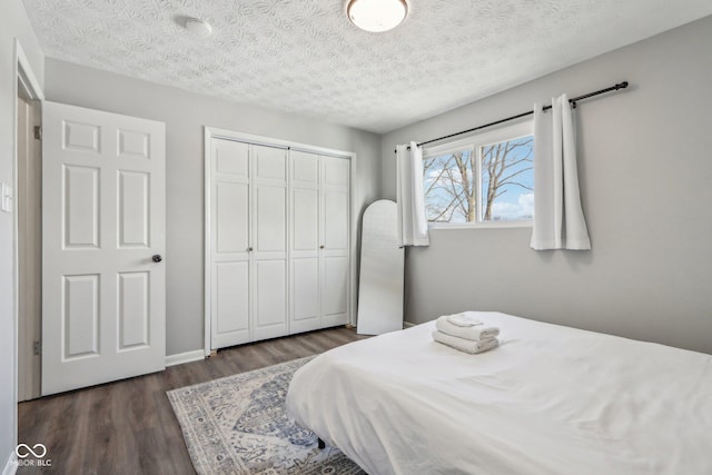 bedroom featuring dark hardwood / wood-style flooring, a closet, and a textured ceiling