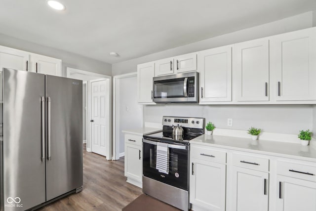 kitchen featuring appliances with stainless steel finishes, white cabinets, and dark hardwood / wood-style flooring