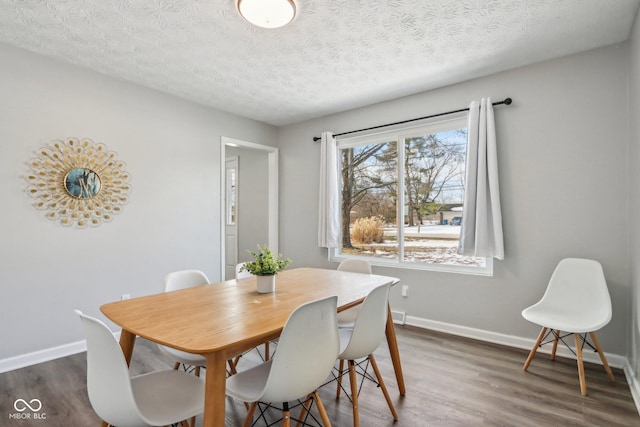 dining space with dark hardwood / wood-style floors and a textured ceiling