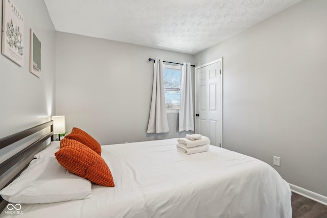 bedroom featuring wood-type flooring and a textured ceiling