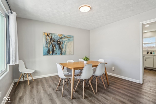 dining space with hardwood / wood-style floors and a textured ceiling