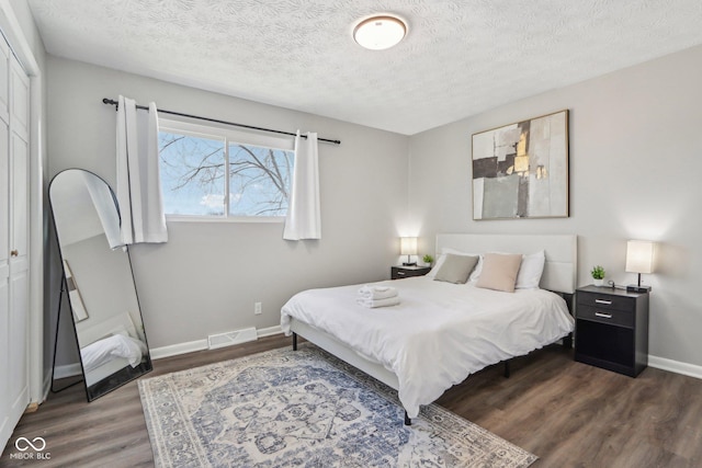 bedroom featuring dark wood-type flooring and a textured ceiling