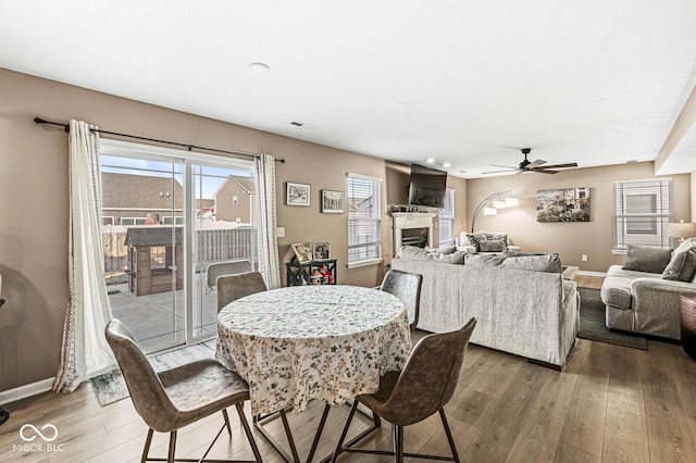 dining space with hardwood / wood-style floors and ceiling fan