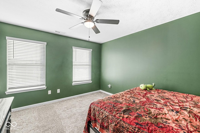 bedroom with a textured ceiling, carpet floors, and ceiling fan