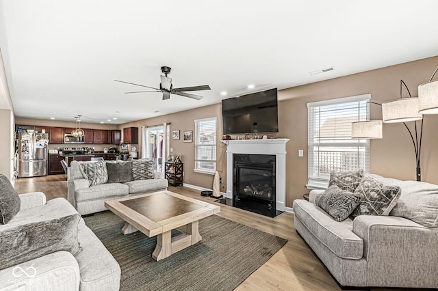 living room featuring ceiling fan and hardwood / wood-style floors