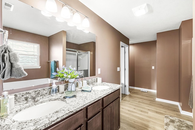 bathroom featuring vanity, hardwood / wood-style flooring, and a shower with door