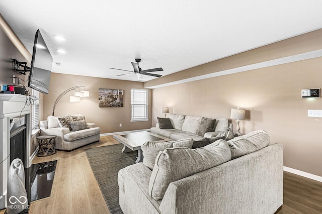 living room with dark wood-type flooring and ceiling fan