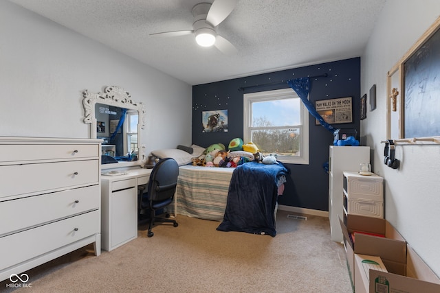 carpeted bedroom with ceiling fan and a textured ceiling