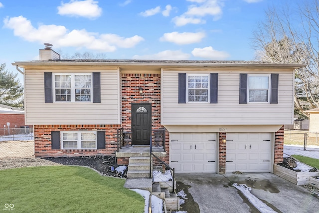 split foyer home featuring a garage and a front lawn