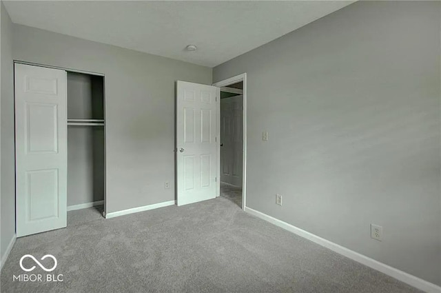 unfurnished bedroom featuring light carpet and a closet