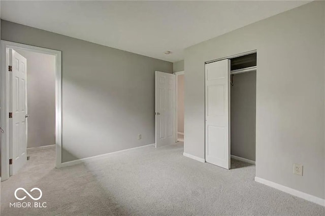 unfurnished bedroom with light carpet and a closet