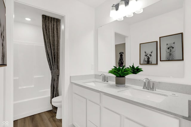 full bathroom featuring shower / tub combo, vanity, wood-type flooring, and toilet