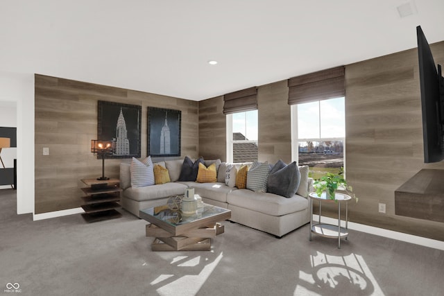 living room with carpet floors and wooden walls