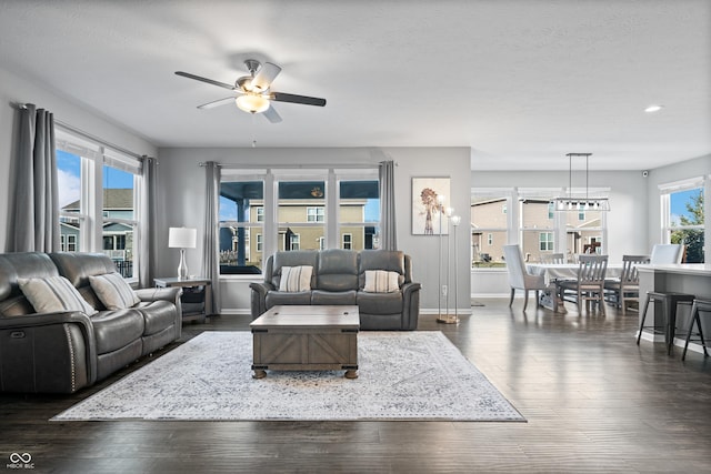 living room featuring dark wood-type flooring, a textured ceiling, and ceiling fan