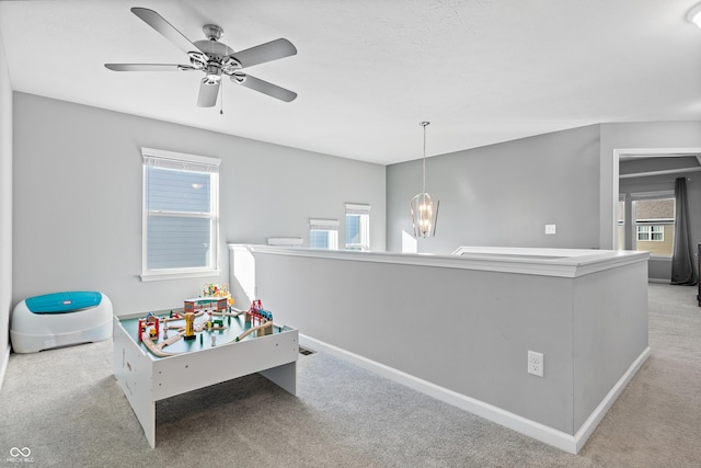 interior space with ceiling fan with notable chandelier and light carpet