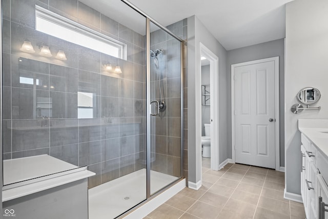 bathroom with vanity, toilet, tile patterned flooring, and a shower with door