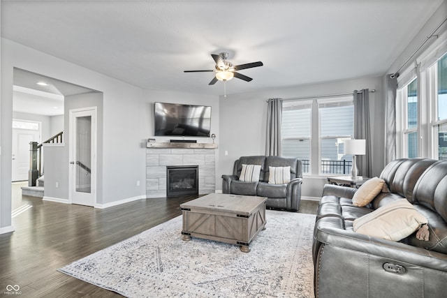 living room featuring dark wood-type flooring and ceiling fan