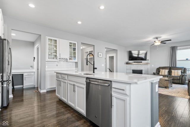 kitchen with sink, stainless steel appliances, an island with sink, and white cabinets