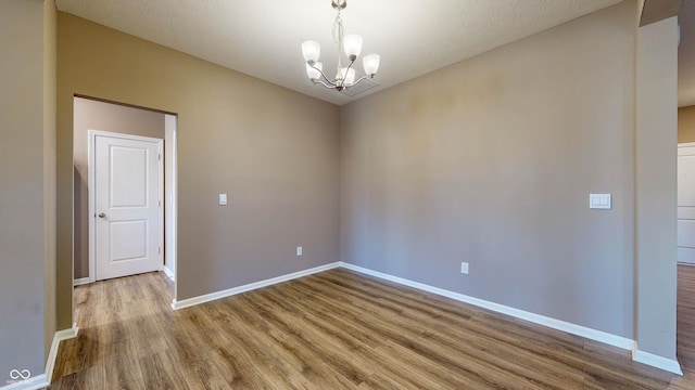 empty room featuring light hardwood / wood-style floors and a chandelier