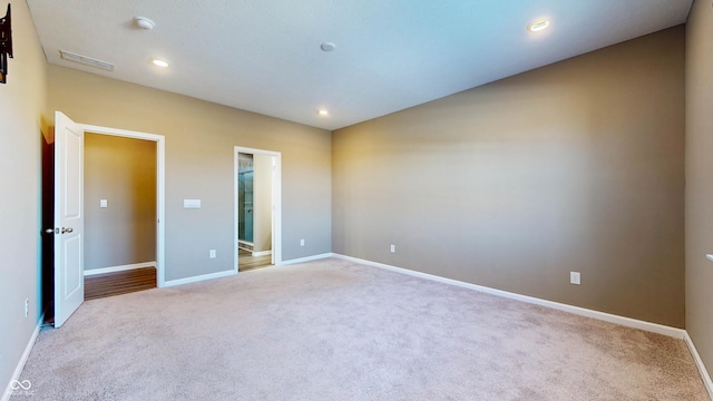 unfurnished bedroom with connected bathroom and light colored carpet