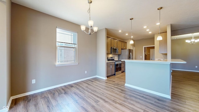 kitchen featuring stainless steel appliances, light hardwood / wood-style floors, a chandelier, and decorative light fixtures