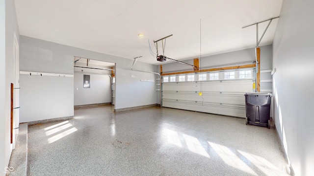 garage with a garage door opener and electric panel