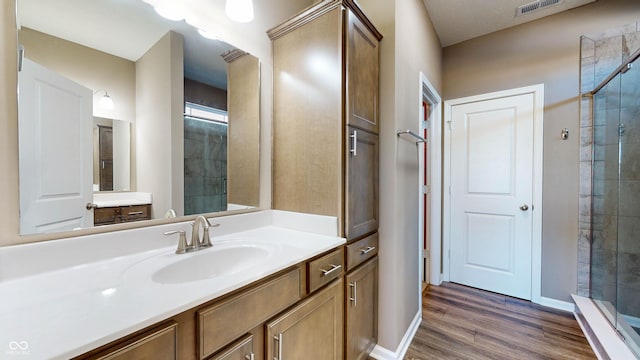 bathroom featuring hardwood / wood-style flooring, vanity, and a shower with door