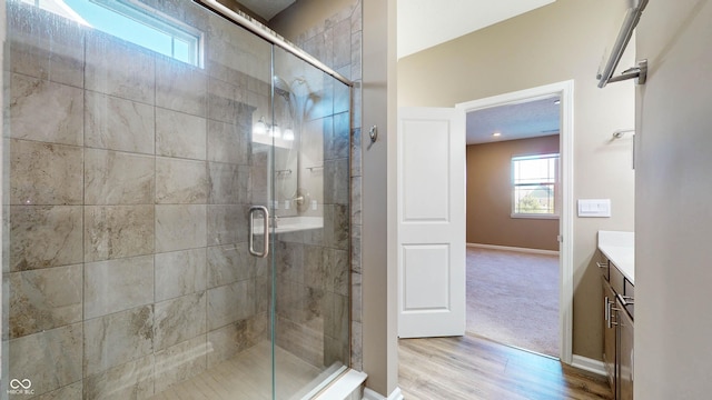 bathroom featuring vanity, an enclosed shower, and hardwood / wood-style flooring