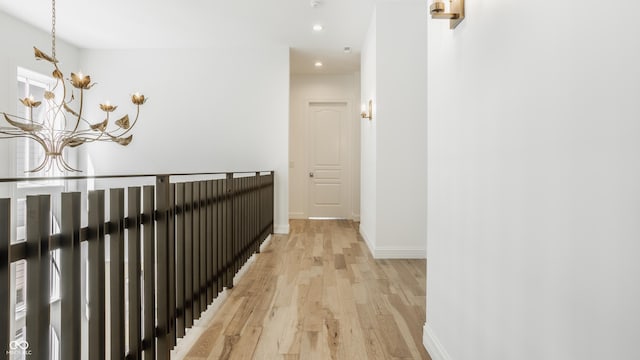 hall featuring an inviting chandelier and light hardwood / wood-style floors